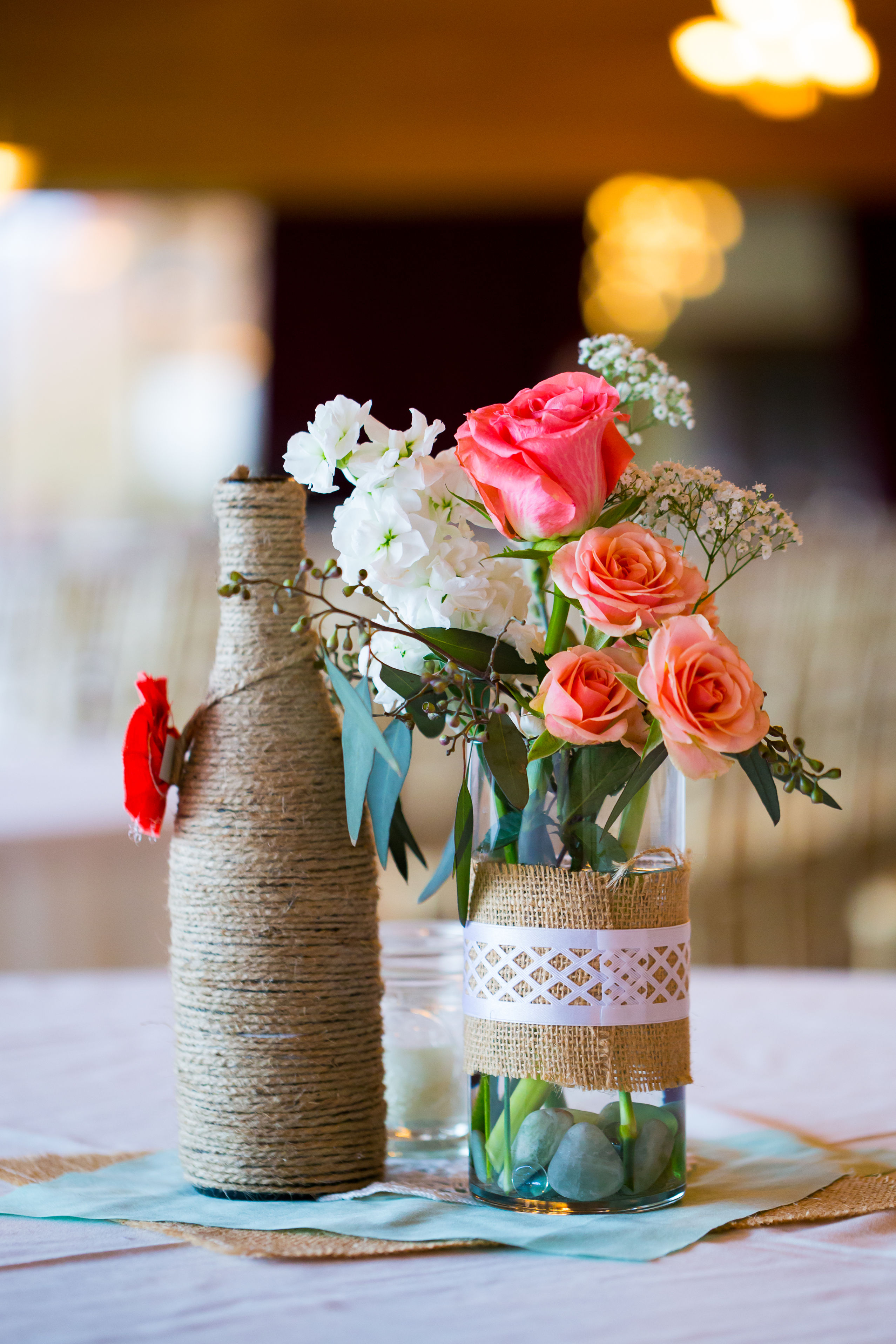 pot et bouteille en verre recouvert de jute et cordelette avec bouquet de fleurs
